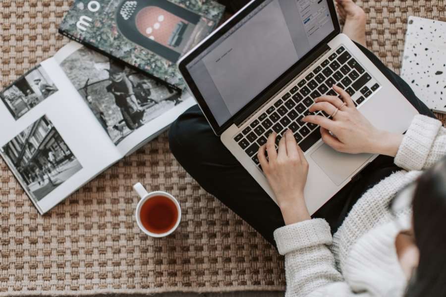 Un bureau de travail lumineux avec un ordinateur portable ouvert, des graphiques imprimés et un bloc-notes.